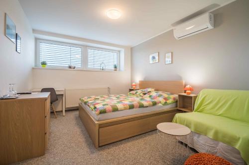 a bedroom with a bed and a desk and a bed and a desk at Penzion ENO in Kelčany