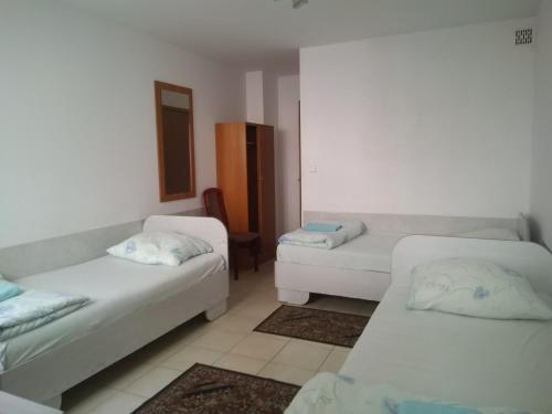 um quarto com duas camas brancas e um espelho em Hostel Malva em Lomianki
