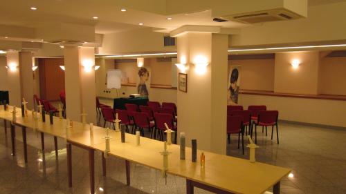 a conference room with red chairs and tables with candles at Hotel Il Duca d'Este in Ferrara