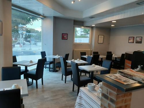 une salle à manger avec tables et chaises et une fenêtre dans l'établissement Le Royalty, à Angers