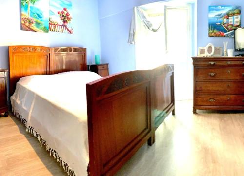 een slaapkamer met een houten bed en een houten dressoir bij casa la valle in San Fedele Intelvi