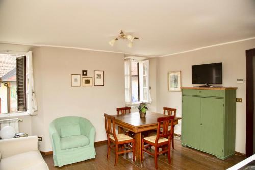 una sala da pranzo con tavolo e armadio verde di Contempora Apartments - Ca' Brenta Patriot a San Fedele Intelvi