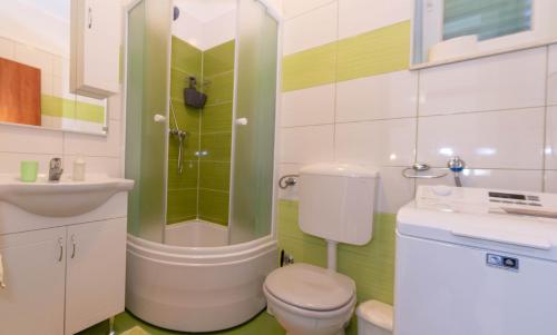 a bathroom with a toilet and a sink and a shower at Apartman Tradicija in Kaštela