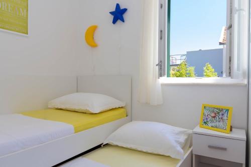 a small bedroom with a bed and a window at Apartman Tradicija in Kaštela