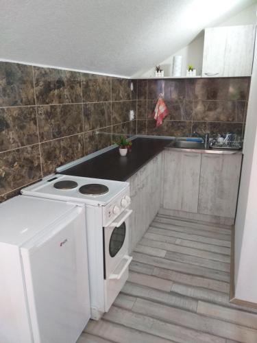 a kitchen with a white stove and a sink at Apartmani Java in Soko Banja