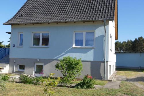 a white house with a gray roof at Ferienunterkuenfte Feldmann in Korswandt