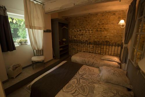 1 Schlafzimmer mit 2 Betten und Ziegelwand in der Unterkunft Bleu D'Orage in Vimoutiers
