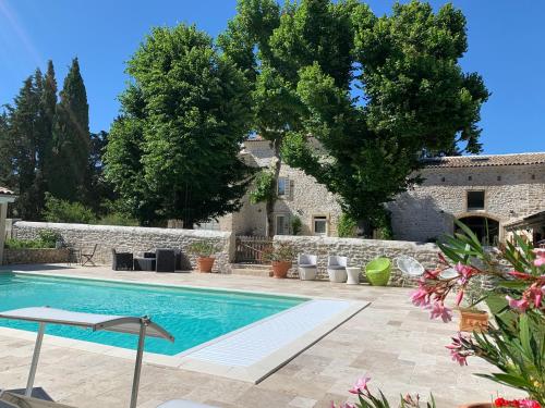 - une piscine dans une cour dotée d'un mur en pierre dans l'établissement Le Mas du Pigeonnier, à Réauville
