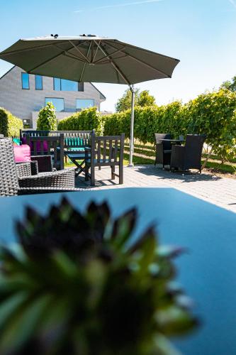 two pictures of a table and an umbrella at Abalona Hotel & Apartments in Dendermonde