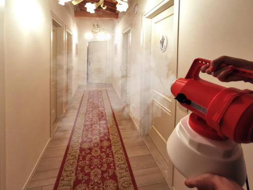 a person using a reditizer to clean a toilet in a hallway at Villa Serena Agriturismo in Montebelluna