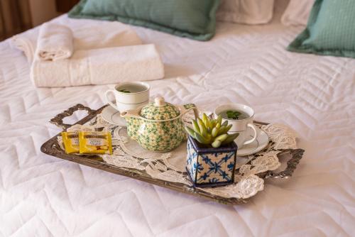 a tray with a tea set on a bed at Pousada Tesouro de Minas - Centro Histórico in Tiradentes