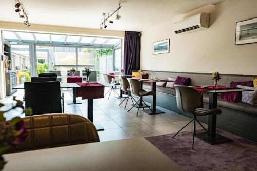 un restaurant avec des tables et des chaises et une grande fenêtre dans l'établissement Abalona Hotel & Apartments, à Termonde