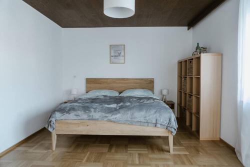 Schlafzimmer mit einem Bett mit einem Kopfteil aus Holz in der Unterkunft Ferienhaus Barbara in Hard