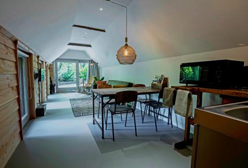 a kitchen and dining room with a table and chairs at Aa Casia vakantiehuis in Zeegse