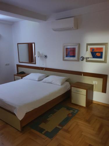 a bedroom with a bed and a table and a lamp at Apartmaji Punta in Veli Lošinj