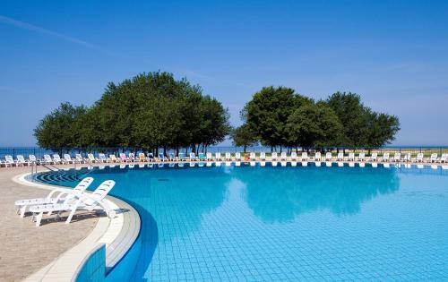 ein großer Pool mit Liegestühlen und Wasser in der Unterkunft Apartments Katoro Plava Laguna in Umag