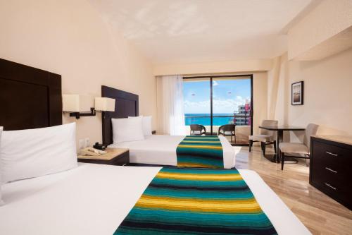 a hotel room with two beds and a view of the ocean at Crown Paradise Club Cancun - All Inclusive in Cancún