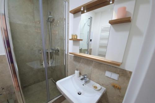 ein Bad mit einem Waschbecken und einer Dusche in der Unterkunft PB Ferienwohnungen - FeWo 2 - Stilvoll eingerichtetes Apartment im Herzen Senftenbergs in Senftenberg
