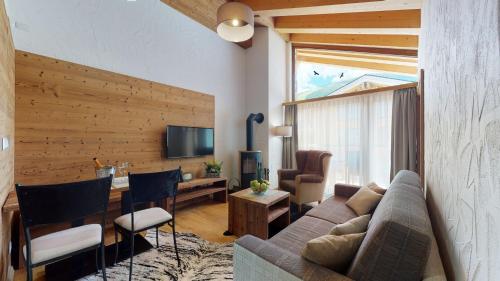 a living room with a couch and a desk with chairs at Apartmány iziJasná & Chalets in Demanovska Dolina