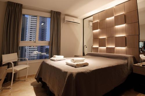 Una habitación de hotel con una cama con toallas. en DOMUS APART en Río Cuarto