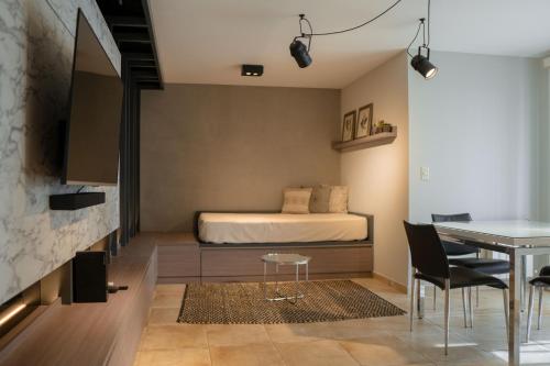 a bedroom with a bed and a table and a dining room at DOMUS APART in Río Cuarto