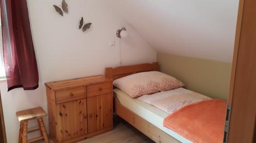 a small bedroom with a small bed and a wooden cabinet at Apartments & Hostel Bohinj in Bohinj