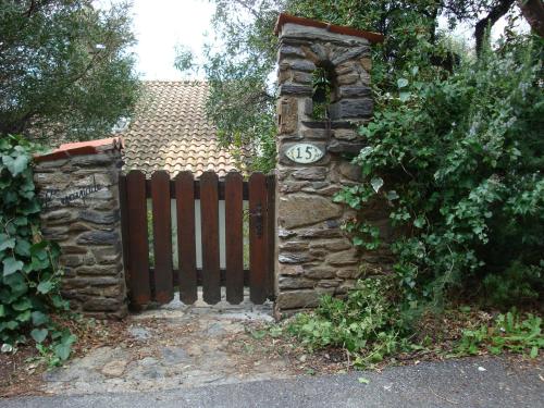 une porte menant à une maison dotée d'une clôture en pierre dans l'établissement Villa l'Escapade, à Rayol-Canadel-sur-Mer