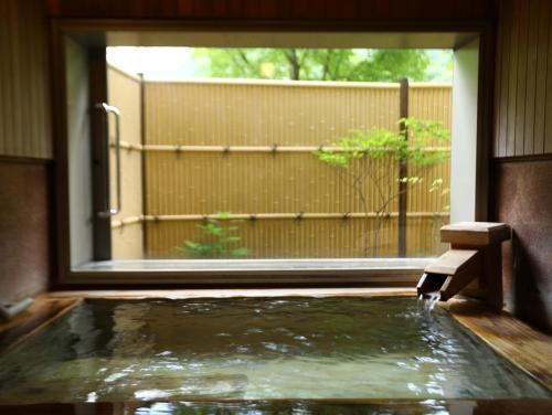 a pool of water in a room with a window at Keiryuso Siorie in Matsumoto