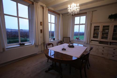 comedor con mesa y algunas ventanas en B&B Snellenstein, en Neerijnen