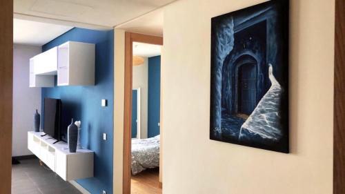 a room with a blue wall with a painting on the wall at Luxury Anfaplace Living Resort in Casablanca