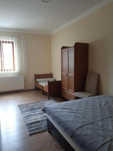 Megyeri Apartman في Pócsmegyer: غرفة نوم فيها سرير وخزانة