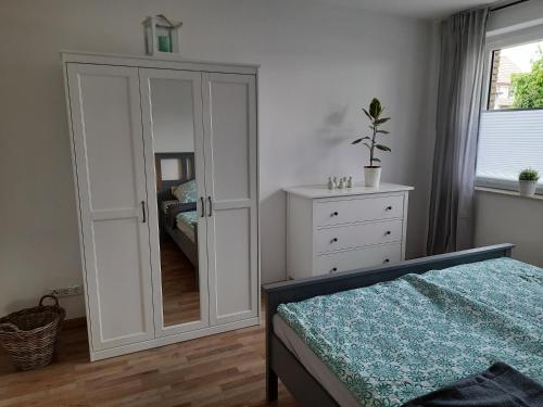 sypialnia z szafą i komodą z lustrem w obiekcie Ferienwohnung Lüdenstein w mieście Bad Rothenfelde