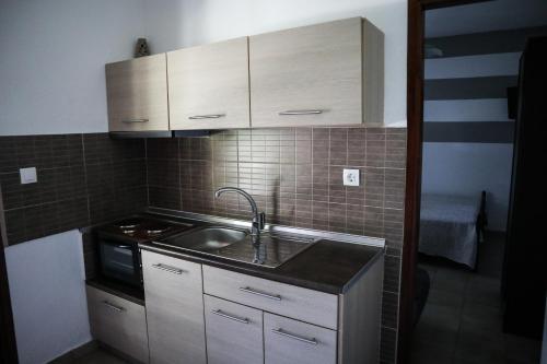 eine Küche mit einer Spüle und einem Herd in der Unterkunft Studios Filio Sonia in Vourvourou