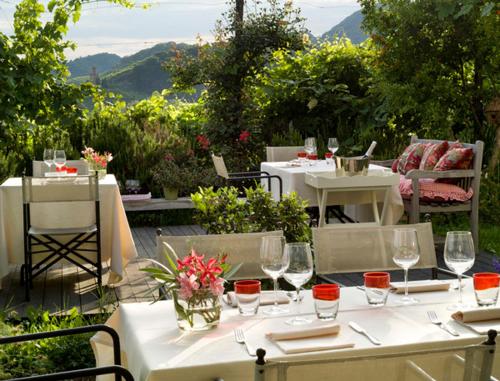 Farra di SoligoにあるCasa Marinelliの白いテーブルと椅子(ワイングラス付)
