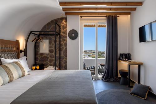 a bedroom with a large bed and a balcony at Vrachos Suites Mykonos in Mýkonos City