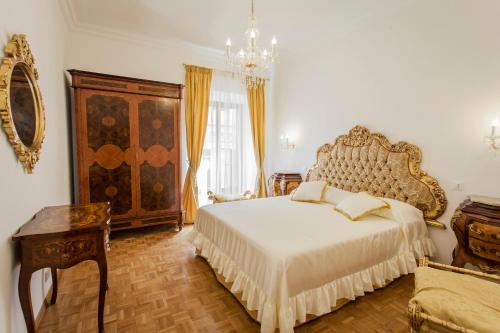 ein Schlafzimmer mit einem großen Bett und einem Kronleuchter in der Unterkunft Suite Sarandrea in Rom