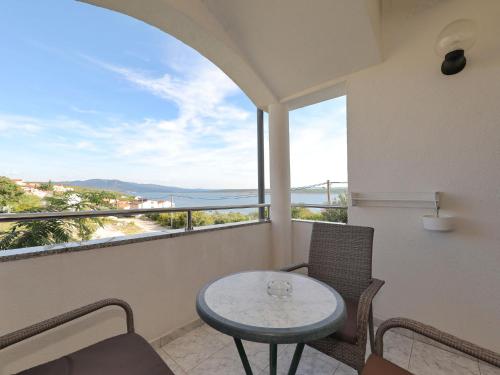stół i krzesła na balkonie z widokiem na ocean w obiekcie Modern Holiday Apartment with Private Pool w mieście Maslenica