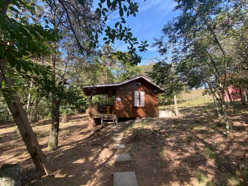 a small wooden cabin in the middle of a forest at Pousada Aguaraguazu in Tibagi