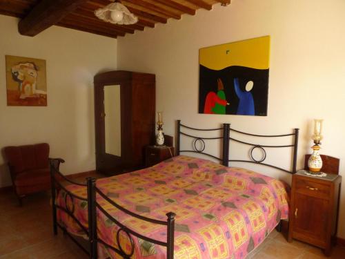 1 dormitorio con 1 cama y una pintura en la pared en Villa with private swimming pool and private garden in quiet area, panoramic views, en Radicondoli