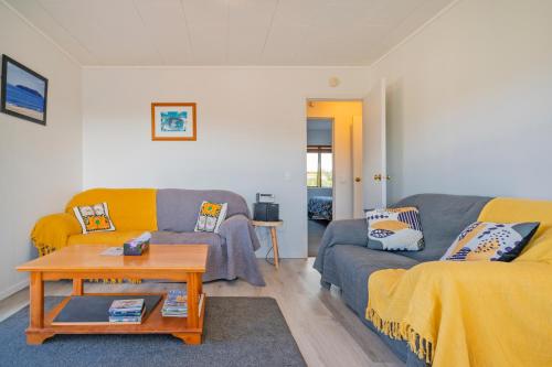 a living room with a couch and a table at Coastal Hill Retreat - Tairua Holiday Home in Tairua
