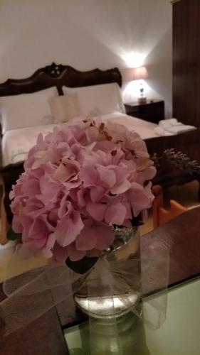 a vase with pink flowers on a table in a bedroom at Petalo Rosso b&b in Lenola