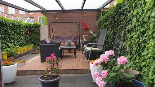 a patio with chairs and flowers in a garden at Sewdien’s Apartment Maashaven in Rotterdam