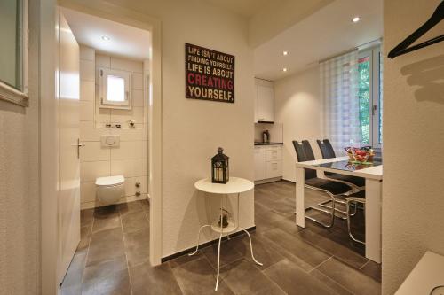 Il comprend une cuisine et une salle à manger avec une table et des toilettes. dans l'établissement da Maurizio Suites, à Berne