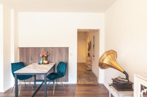 蓋爾森基興的住宿－GATSBY Apartment，一间带桌子和绿色椅子的用餐室