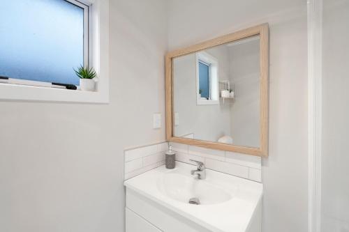 uma casa de banho branca com um lavatório e um espelho em Fifteen B - National Park Holiday Home em National Park