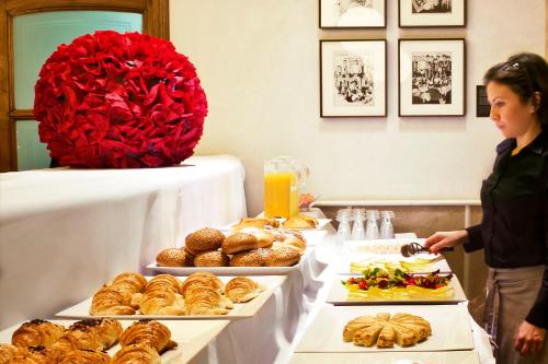 a woman standing in front of a buffet of food at Hotel Astoria in Barcelona