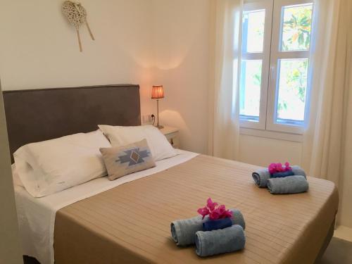 a bedroom with a bed with two towels on it at Dream House in Ornos