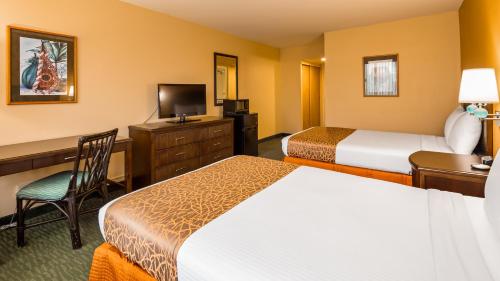a hotel room with two beds and a desk at Airport Honolulu Hotel, Trademark Collection by Wyndham in Honolulu