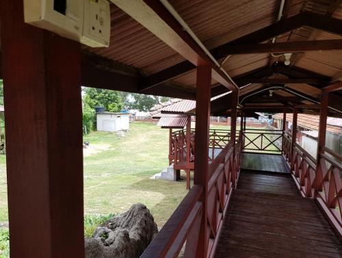 un porche de un edificio con una pasarela de madera en Kampong Style Homestay Pengkalan Balak - Sea View, en Pengkalan Balak