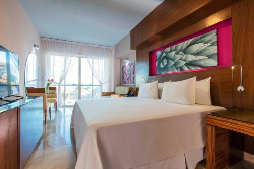 a bedroom with a large bed with a red painting on the wall at Krystal Grand Los Cabos - All Inclusive in San José del Cabo